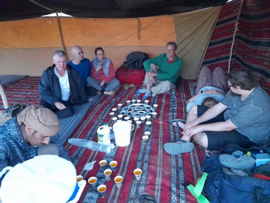Al KhuraybahFeynan wild camp的一群人坐在帐篷里