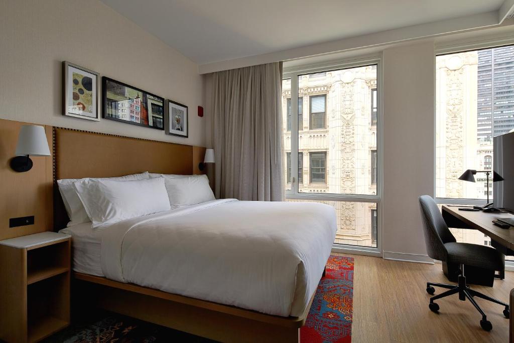 纽约Hotel Indigo NYC Financial District, an IHG Hotel的配有一张床、一张书桌和一扇窗户的酒店客房
