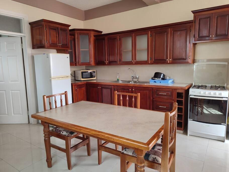 PortsmouthIso’s Vacation Rental Apartment #7的厨房配有桌子和白色冰箱。