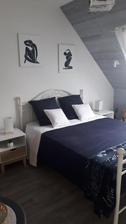 勒孔凯Kerivin的一间卧室配有一张带蓝色和白色枕头的床