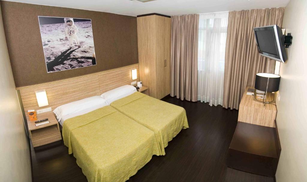 拉科鲁尼亚月亮酒店的配有一张床和一台平面电视的酒店客房