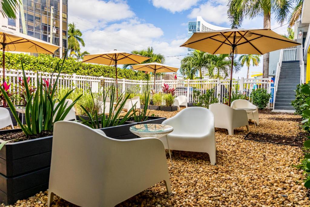 迈阿密Up Midtown的一个带桌椅和遮阳伞的庭院