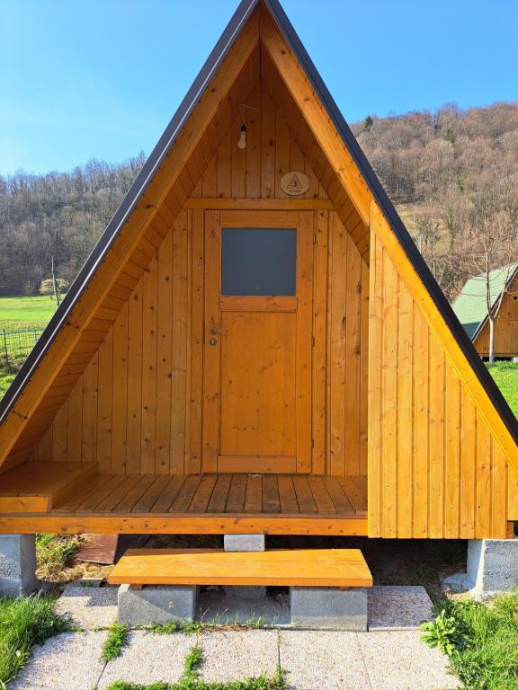 托尔明GLAMPING HIŠKe PETRIN的一座大型木制建筑,顶部设有一扇门