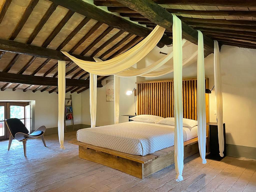 维泰博波得雷德拉克乡村魅力酒店的一间卧室配有一张天蓬床和一把椅子