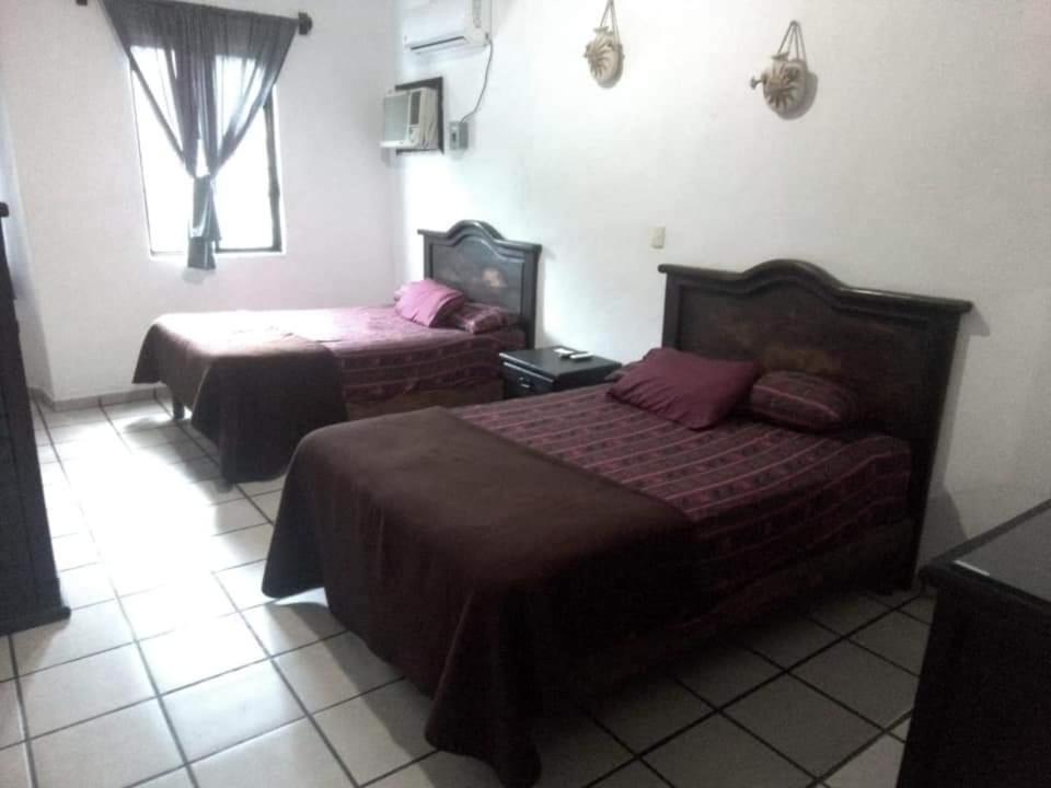 MatlapaHotel Raíz de Sierra的酒店客房设有两张床和窗户。