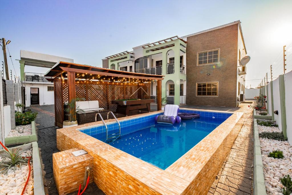 阿克拉Cloud9 Luxury Apartments的一个带游泳池和房子的后院