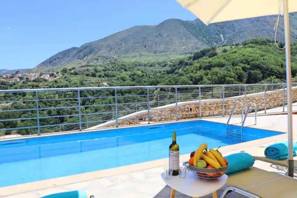 KástellosVilla Veneciana with Heated Pool的一个带桌子和一瓶葡萄酒的游泳池