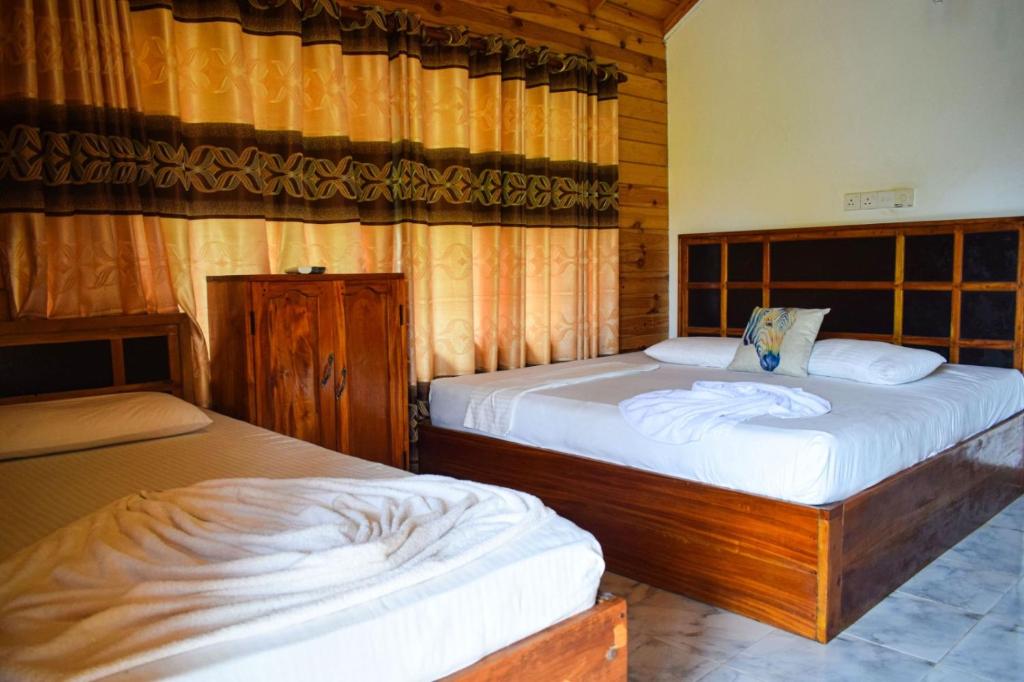 尼拉瓦利Mithra Paradise Beach Hotel的一间卧室,配有两张床