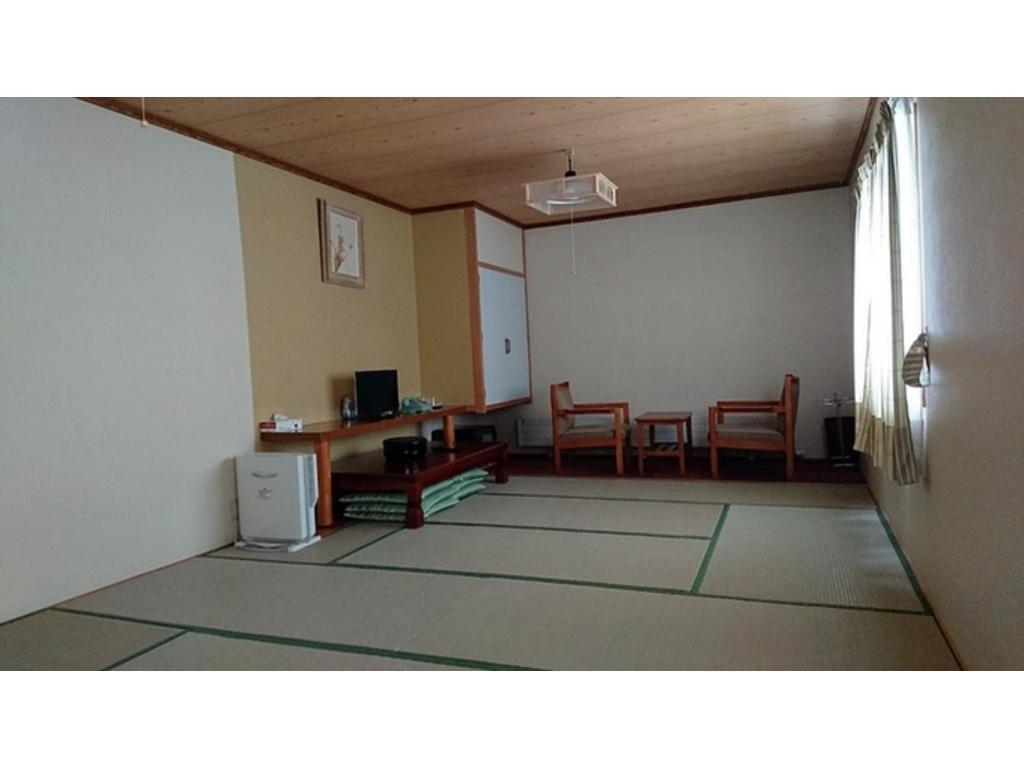 北见Onsen Hotel Tsutsujiso - Vacation STAY 03256v的一间带桌椅的客厅