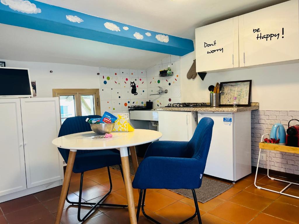 帕多瓦mansardina artista的厨房配有桌子和2把蓝色椅子