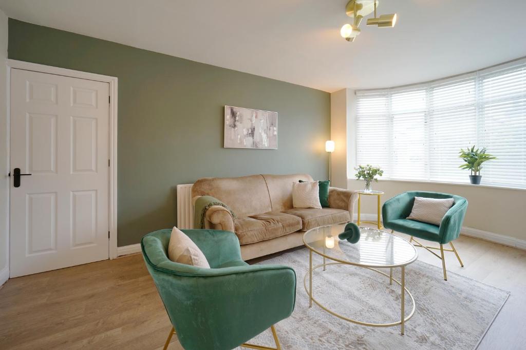 MoortownStunning luxury 3 bed house with garden in North Leeds的客厅配有沙发、两把椅子和一张桌子