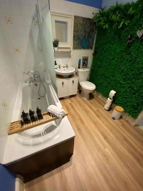 朴次茅斯Ann Apartments opposite the Pier with sea view的浴室配有绿色墙壁和浴缸。