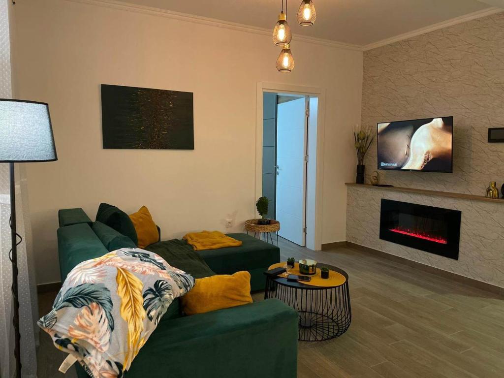 Stari BanovciLa Vista的客厅设有绿色沙发和壁炉