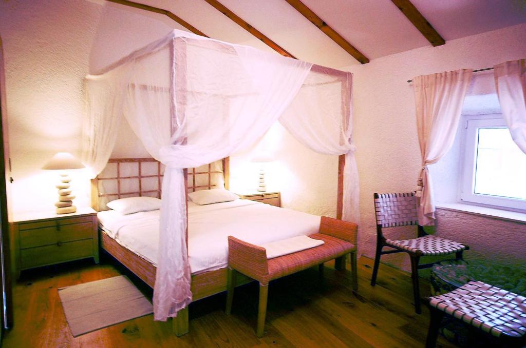 克尔克普拉卡精品酒店的一间卧室设有天蓬床和窗户。
