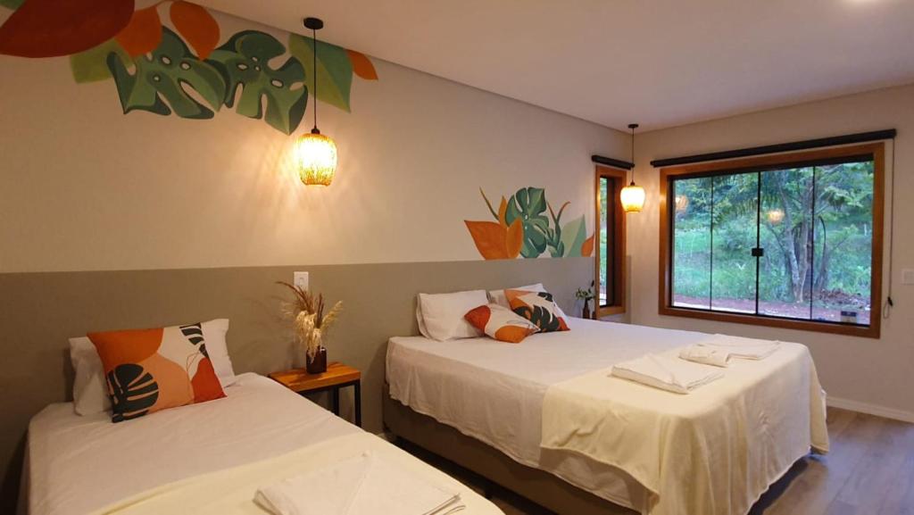圣安东尼奥-杜皮尼亚尔Espaço Canto的一间卧室设有两张床和窗户。