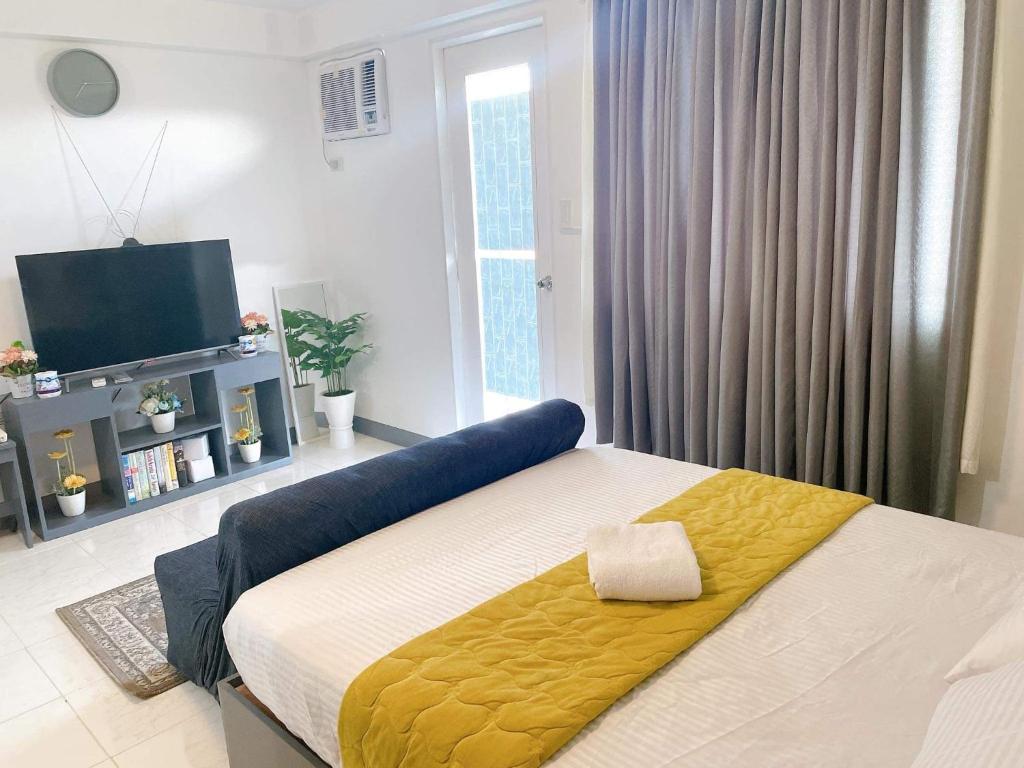 达沃市Spacious condominium的一间卧室配有一张黄色毯子床