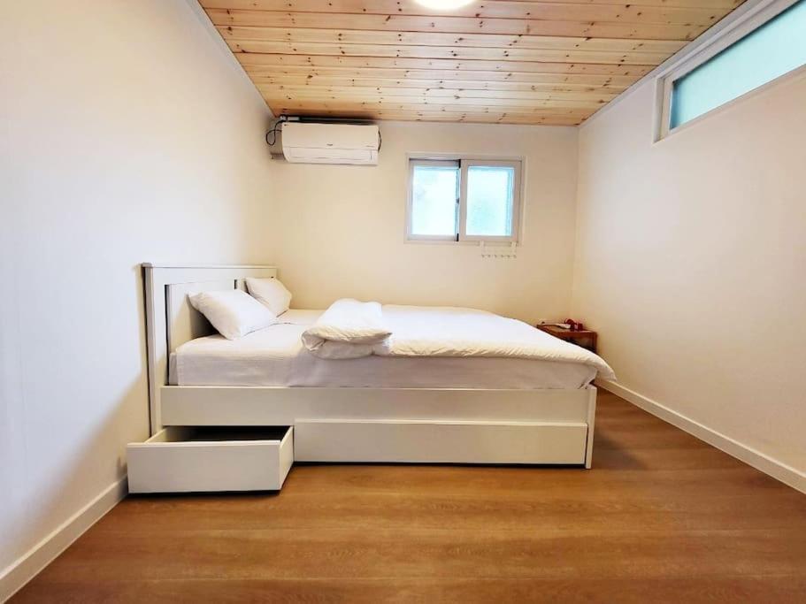 首尔Sam House 2 Seochon的卧室位于客房的角落,配有一张床