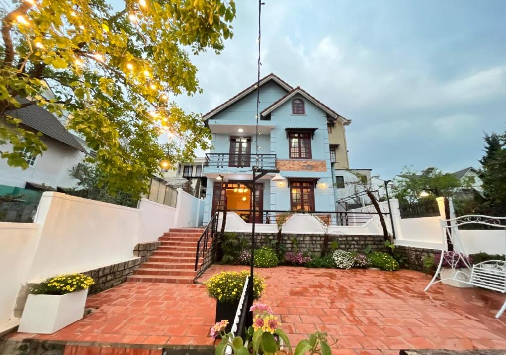 大叻NHỚ House IV的一栋前面有砖砌车道的房子