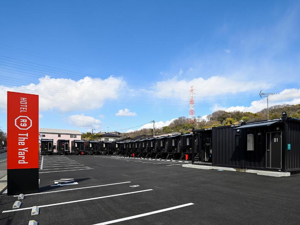 福山HOTEL R9 The Yard Fukuyama的停车场,有一排黑货柜