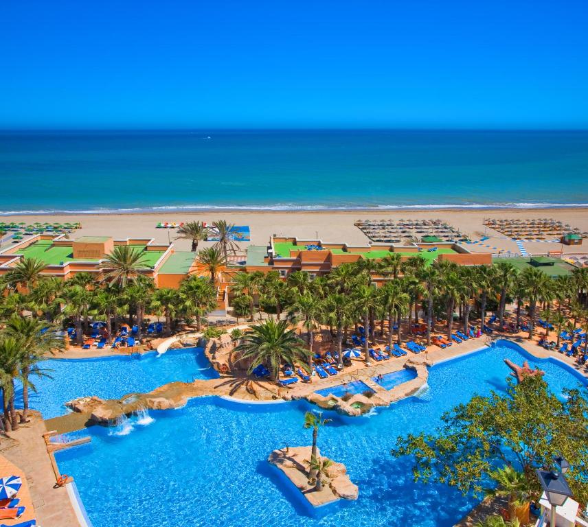 滨海罗克塔斯Playacapricho的享有带游泳池和海滩的度假村的空中景致