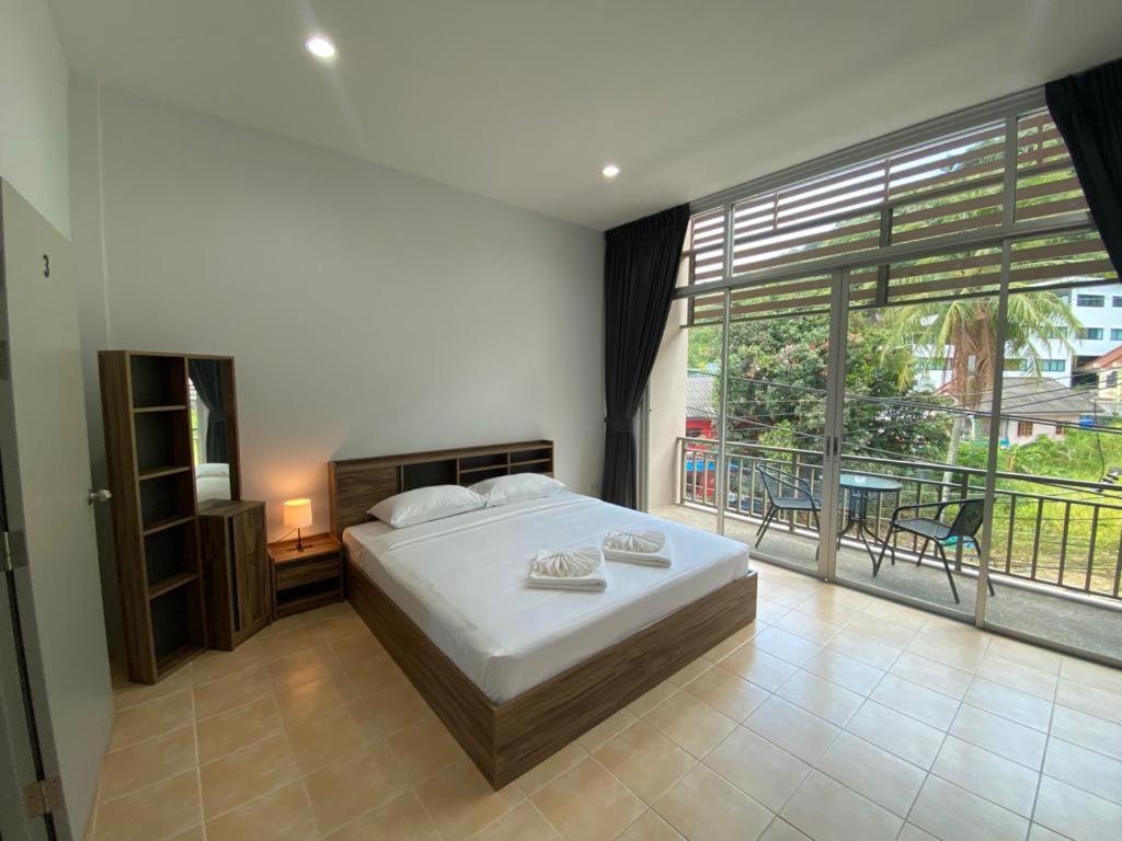 卡塔海滩L&P Guesthouse的一间卧室设有一张床和一个大窗户