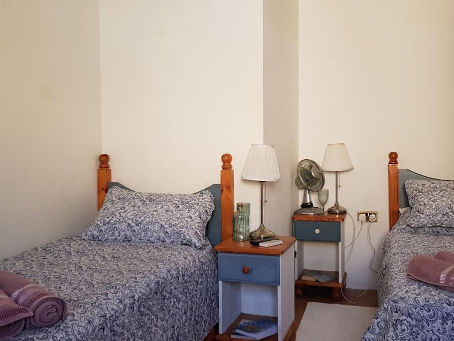Traditional Maltese House in Birgu的一间卧室配有两张床和一张带台灯的桌子
