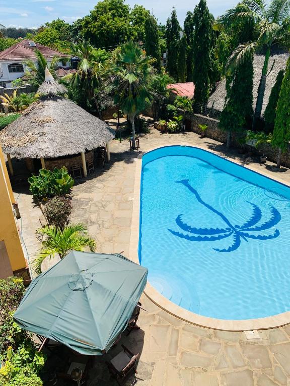 尼亚利Ltorec的一座带遮阳伞的游泳池位于度假酒店旁
