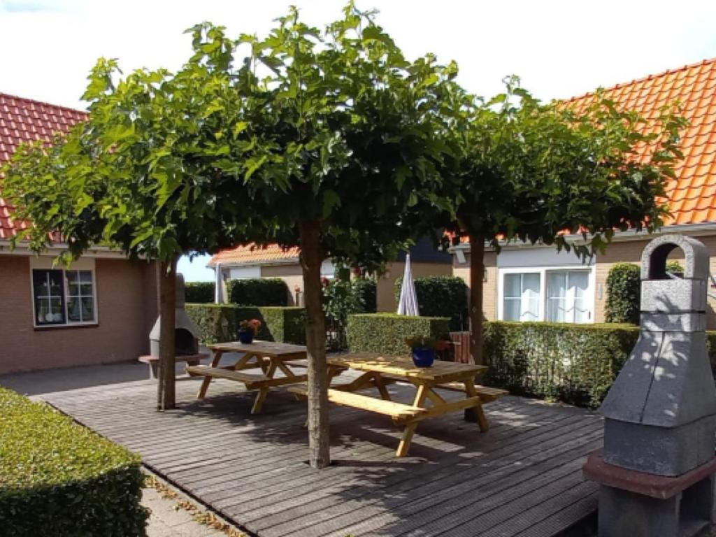 霍勒姆De Friese Antillen的庭院设有两张野餐桌和一棵树