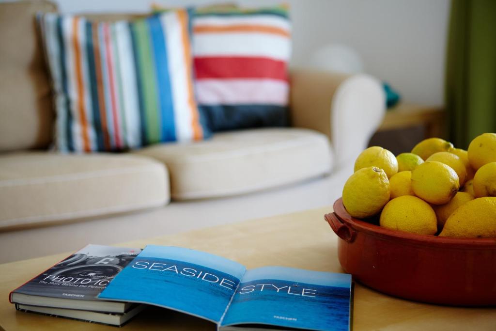 Vokaria阿默蓝多斯海景公寓酒店的书旁边的桌子上放一碗柠檬
