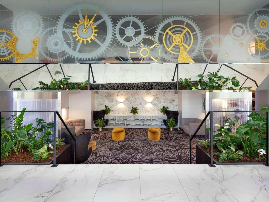 比尔比尔美居酒店的大堂种植了植物,墙上挂着时钟