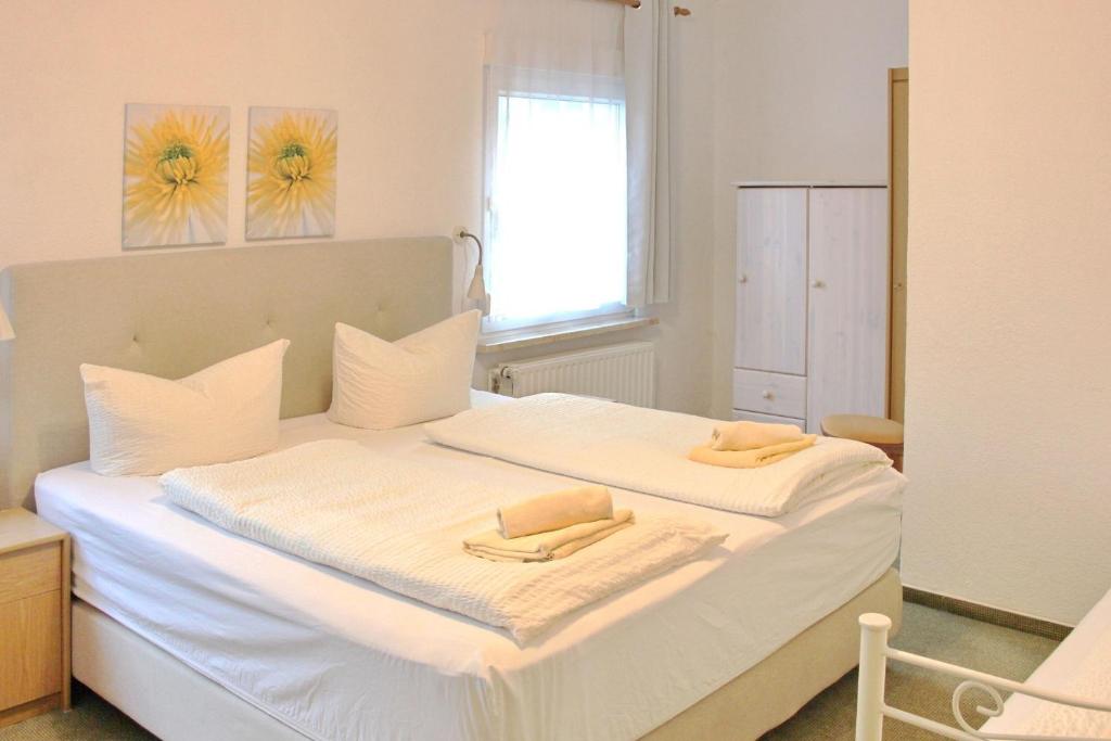 吕本瑙Pension An der Kamske, 3BZ 2的卧室配有白色的床和2条毛巾
