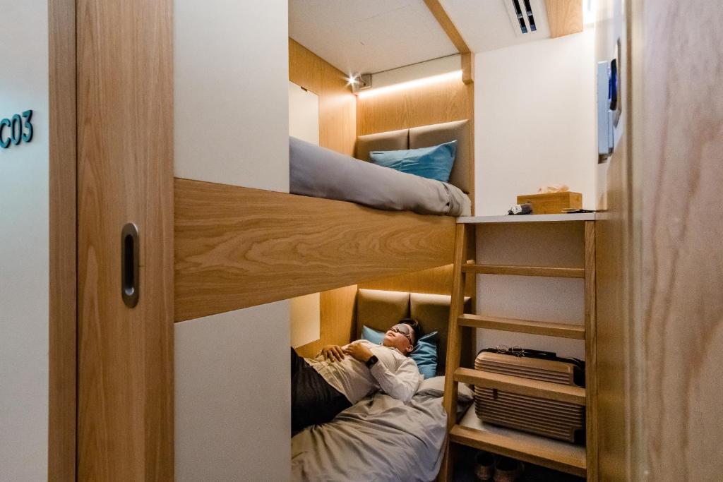 多哈sleep 'n fly Sleep Lounge & Showers, NORTH Node - TRANSIT ONLY的一间设有两张双层床的房间,其中有一位男士