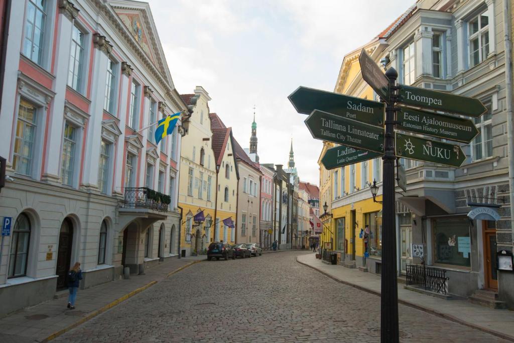 塔林Old Town Tallinn Luxury Residence的街道中间的街道标志,有建筑物