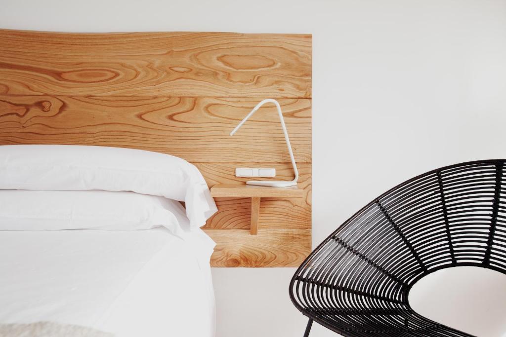 Feás米兰达酒店的卧室配有白色的床和木墙