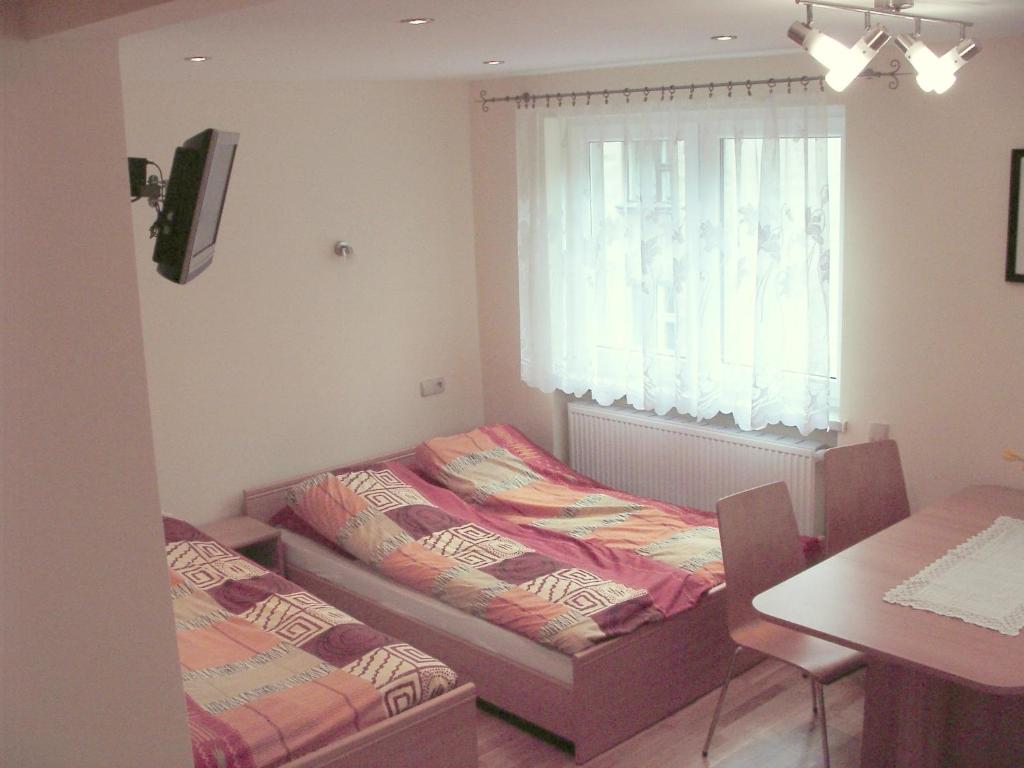 伊斯泰布纳Apartamenty Kubalonka的配有桌子和窗户的客房内的两张床