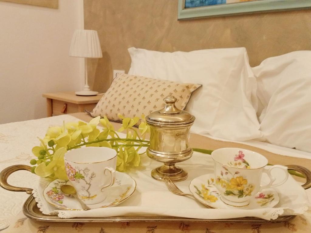 斯培西亚COVO DI LEVANTE的床上的托盘,上面有2杯茶和茶具