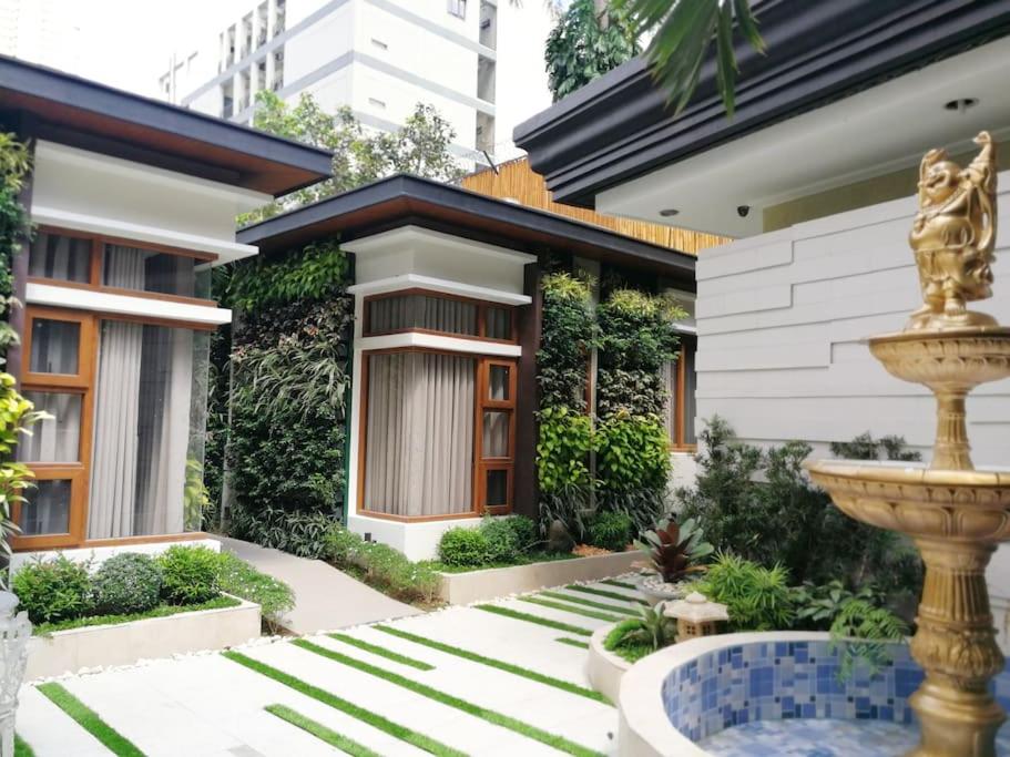 马尼拉Adria Residences - Emerald Garden - 2 Bedroom Unit for 4 person的前面有喷泉的房子