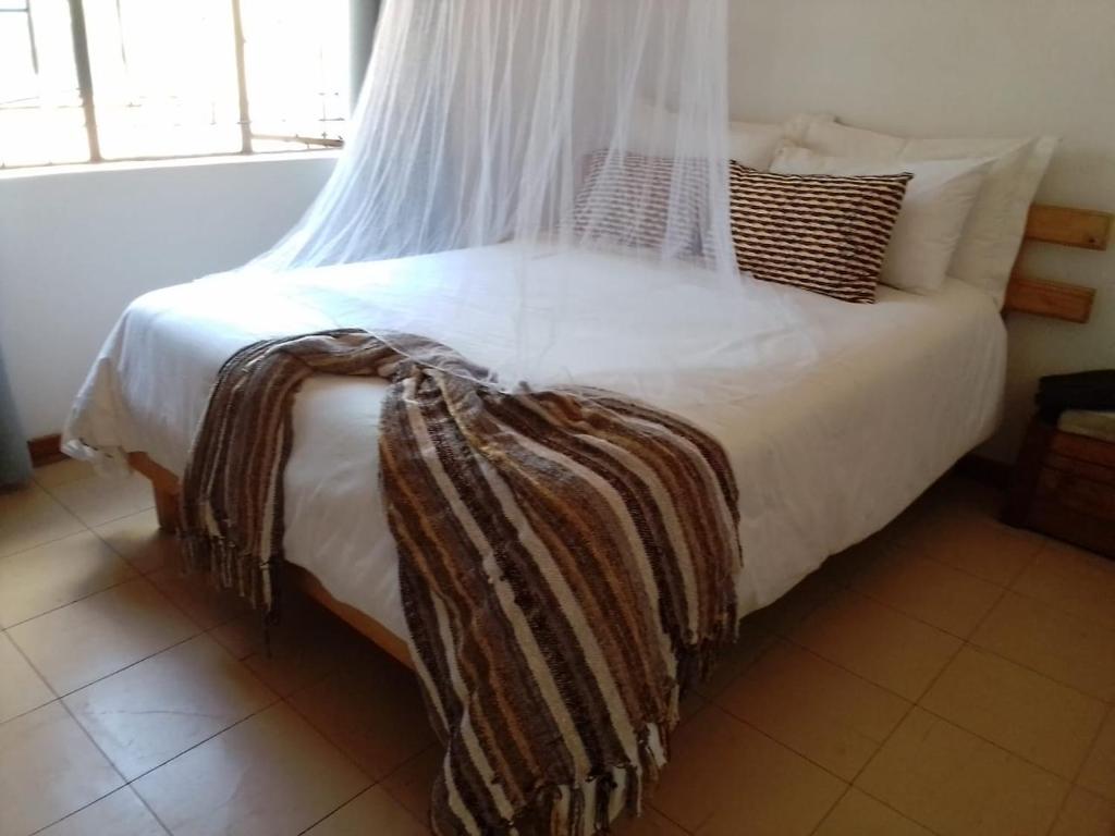 卡萨内Plateau Home的一间卧室配有带白色床单和枕头的床。