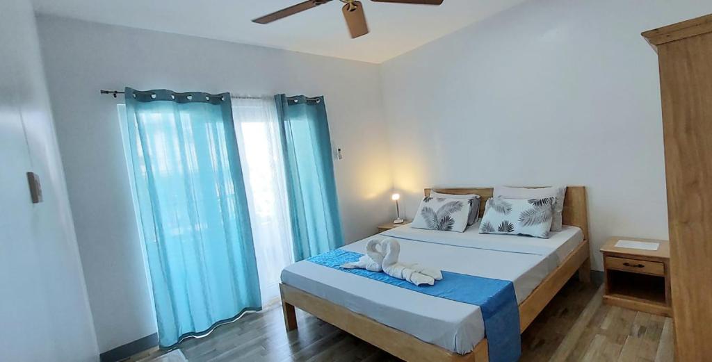 莫阿尔博阿Beyond Island的一间卧室配有一张带蓝色窗帘的大床