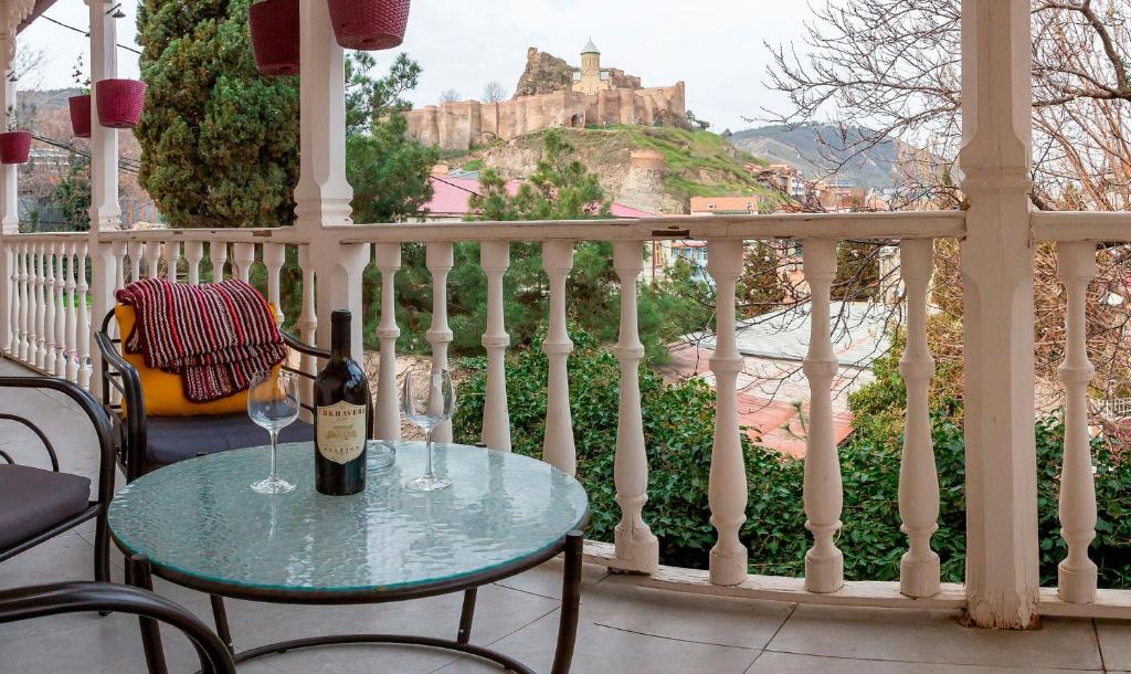 第比利斯Gvino Minda的城堡阳台的一张桌子和一杯葡萄酒