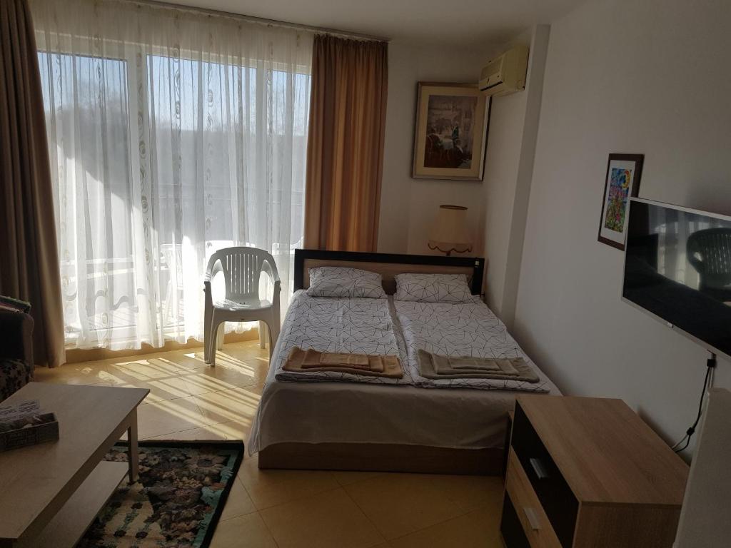 阿赫洛伊Midia Grand Rezort的一间卧室配有一张床、一张桌子和一台电视