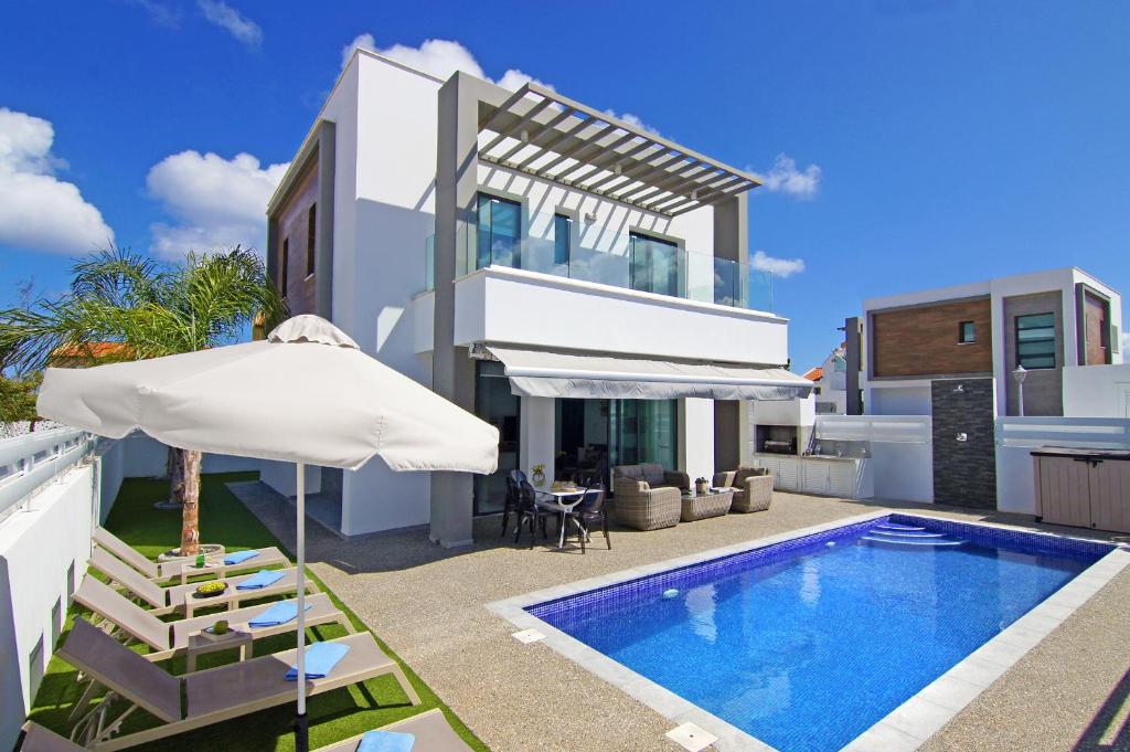 普罗塔拉斯Villa Martha的一座带游泳池和遮阳伞的别墅