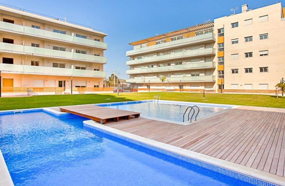 圣安东尼奥·德·卡隆NEW! Apartamento con 2 piscinas, parque infantil, a 1 min de la playa的大楼前的游泳池