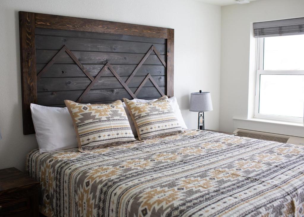 EncampmentPine Lodge的一间卧室配有一张大床和木制床头板