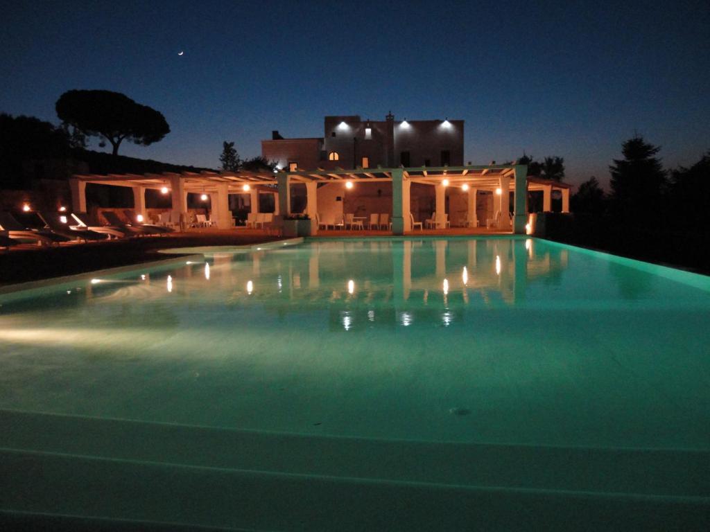 莫诺波利马赛利亚圣塔特雷莎酒店的游泳池,后方是一座房子