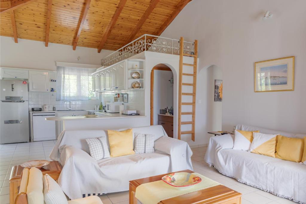 卡拉马孔Heliotropio的一间带2张白色沙发的客厅和一间厨房