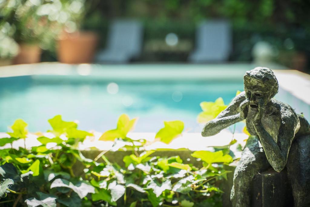 阿维尼翁巴拉卡涅花园住宿加早餐旅馆的坐在游泳池旁的小女孩雕像