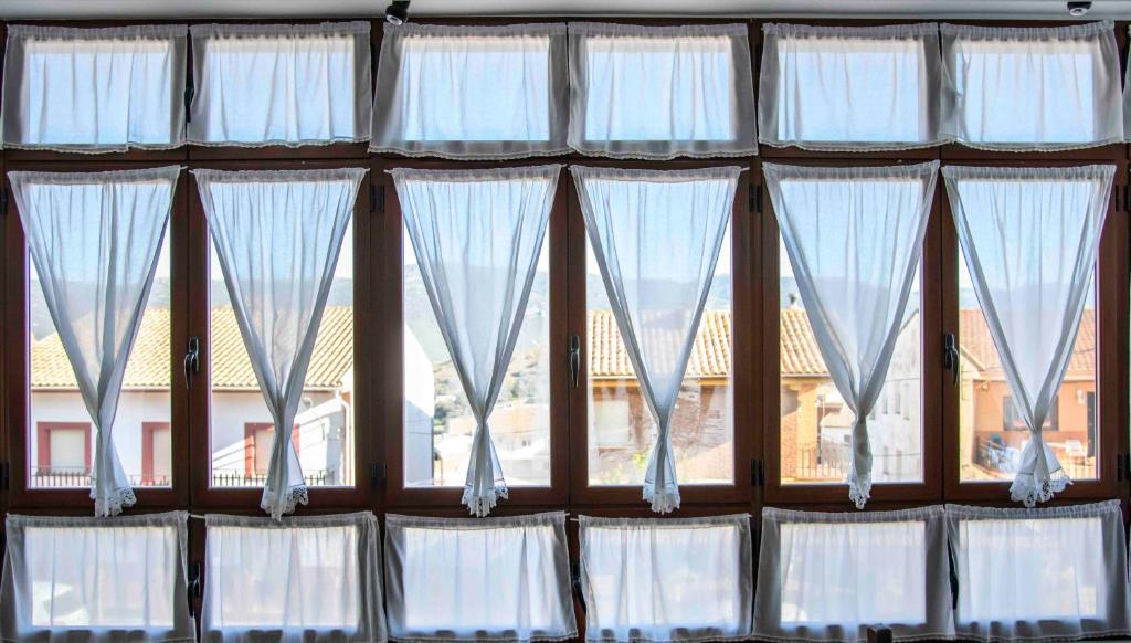 Puebla de Don RodrigoLa Balconera de Ana的一组窗户,里面装有白色窗帘