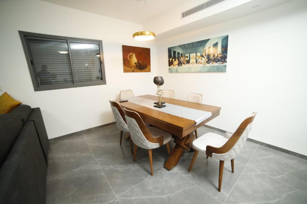 提比里亚חופשה בטבריה בבית ענק ל 8 אנשים גדול וחדש的一间带木桌和椅子的用餐室