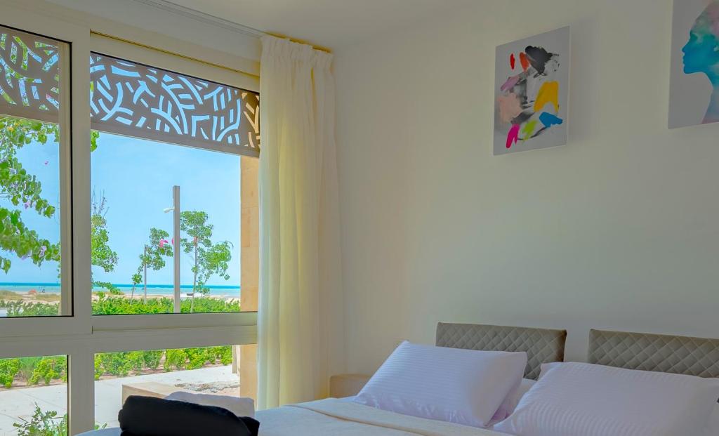 赫尔格达Mangroovy Seaview 3BR Beach and Pool Free access的一间卧室配有一张床,享有海景